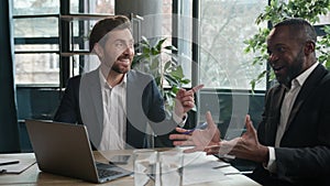 Two diverse business men talking laughing fun at office meeting African and Caucasian businessmen talk multiracial