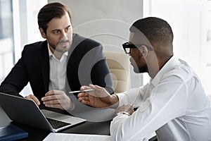 Two diverse businessmen negotiating in modern office during meeting