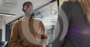 Two diverse businesspeople discussing together and standing at table