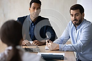 Two diverse hr manager listening to candidate at job interview