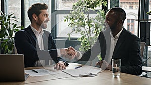 Two diverse multiracial businessmen Caucasian man and African American businessman partners men signing contract