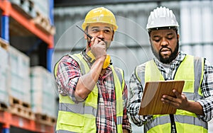 Two diverse professional male workers holding board, checking shipping stocks in storage, warehouse or factory for delivery,