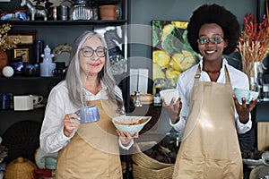 Two diverse saleswomen posing together at decor store photo