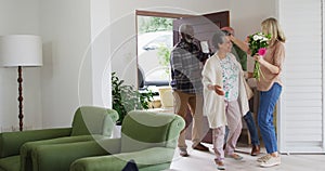 Two diverse senior couples hugging and greeting each other at home