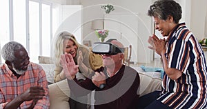 Two diverse senior couples sitting on a couch caucasian man is using vr googles