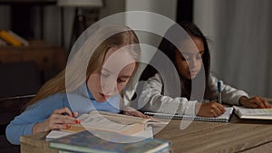 Two diverse teeanage girls doing homework at home