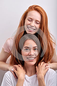 Two diverse women lesbian couple hugging looking at camera, close up portrait