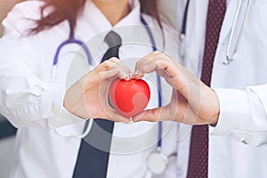 Two docter holding a red heart, health care concept.