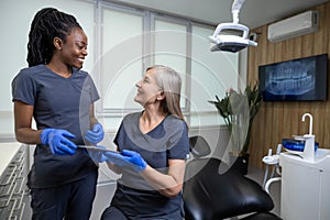 Two doctor colleagues discussing something during changeover in a clinic photo