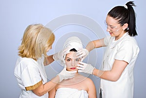 Two doctor holding hands on woman face