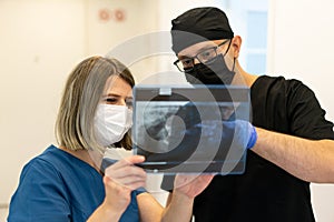 Two doctors checking x-ray image in hospital, high quality photo