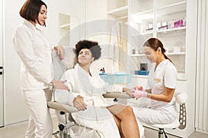 Two doctors consulting client in beauty salon during procedure