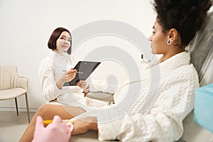 Two doctors consulting lady in beauty salon during procedure