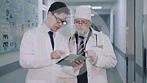 Two doctors consulting using tablet with MRI. 4K
