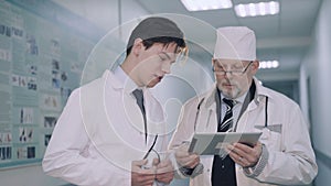 Two doctors consulting using tablet with MRI. 4K