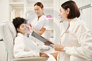 Two doctors consulting woman in beauty salon