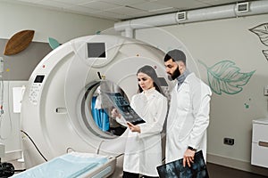 Two doctors discussing x-rays after CT scan of patient abdomen. CT Computed tomography scan procedure to obtain detailed
