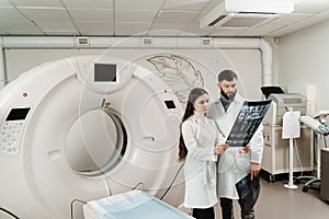 Two doctors discussing x-rays after CT scan of patient abdomen. CT Computed tomography scan procedure to obtain detailed