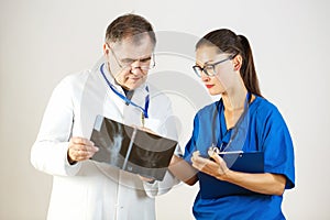 Two doctors are examining an X-ray and are discussing the problem