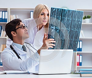 Two doctors examining x-ray images of patient for diagnosis