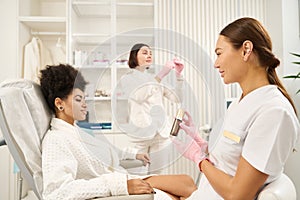 Two doctors and lady in beauty salon during procedures