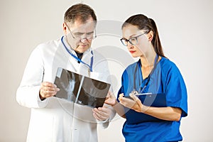 Two doctors look at an x-ray of the hand and discuss the problem