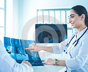Two doctors studying x-ray image, consulting in bright office