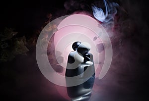 Two doll hugging on table with flowers and moon decoration Lighted background with smoke.Love concept. Greeting or gift card desig