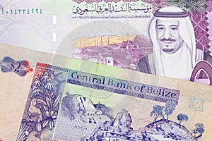 A two dollar bill from Belize with a Saudi riyal note photo