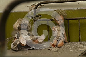 Two dolls over a rusty bed inside an abandonated kinder garden at chernobyl