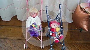 two dolls sitting baby carriages