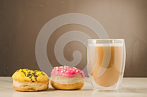 Two donuts in glazes and a glass of a cappuccino/two donuts in g