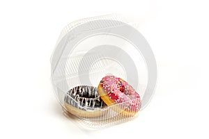 Two donuts in a plastic box on a white background