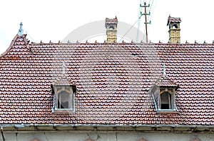 Two dormer windows in a red tiled roof