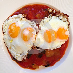 Two double yolk fried eggs on ratatouille.