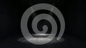 Two dramatic spotlights illuminate a dark empty stage floor creating circular pools of light in a vast black room setting the