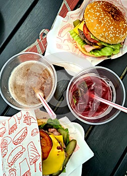 two drinks and two burgers in a summer open-air bistro