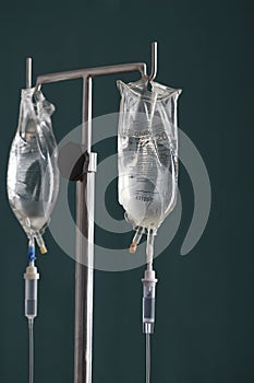 Two drip bags on stand against black background