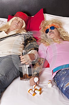 Two drunk male friends reclining on bed