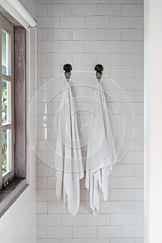 Two dry, clean and fresh towel on wall hanger in bathroom