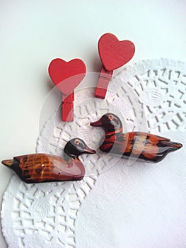 Two ducks of wooden and red hearts