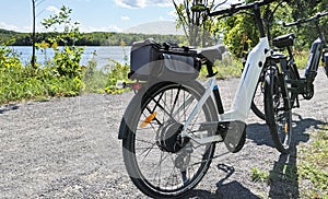 Two e-bikes on a trail beside a river photo