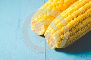 Two ears of boiled appetizing corn on a blue background/two ears of boiled appetizing corn on a blue background. Healthy food.