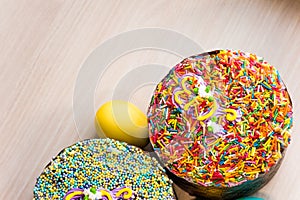 Two Easter cakes with colored topping and colored egg, copy space