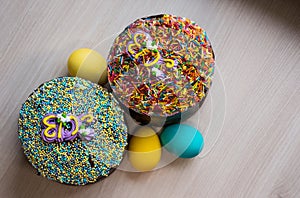 Two Easter cakes and three colored eggs, yellow and blue