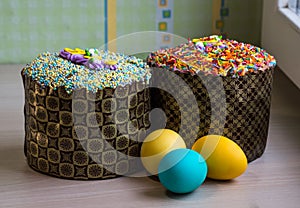 Two Easter cakes and three colored eggs, yellow and blue