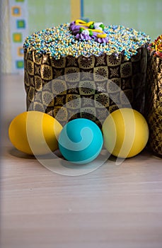 Two Easter cakes and three colored eggs, yellow and blue