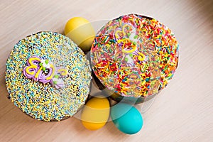 Two Easter cakes and three colored eggs, yellow and blue