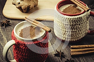 Two eggnog mugs with grated nutmeg, cinnamon and cake/two eggnog