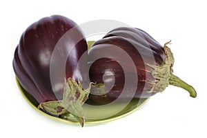 Two eggplant on green plate isolated on white